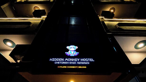 A building with a sign reading "Hidden Monkey Hostel" and a monkey illustration. - Hidden Monkey Hostel Chet Singh Ghat (Varanasi)