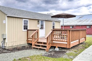 A small, single-story building with a wooden deck and a covered patio area.