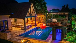 Un jardin avec une piscine, un espace salon extérieur et une terrasse couverte.