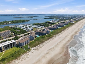 Un hôtel situé sur la côte, composé de plusieurs bâtiments, avec une plage et un port de plaisance.