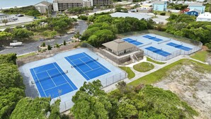 A coastal hotel with multiple tennis courts, a parking area, and a view of the ocean. - Well-Appointed Condo with WiFi, Washer/Dryer & Shared Pools, Tennis (Atlantic Beach)