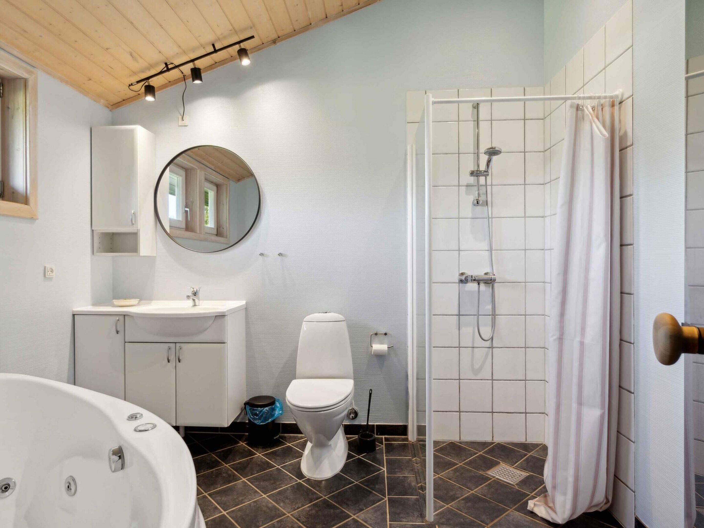 A bathroom with a bathtub, toilet, sink, and shower.