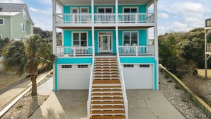 Ein zweistöckiges Haus mit einer Veranda und einer Treppe, die zum Eingang führt.
