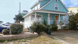 A two-story house with a porch and a small garden. - Bullard Cottage: In the heart of Atlantic Beach w/ocean views (Atlantic Beach)