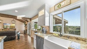 Una cocina moderna con un ventanal grande, horno empotrado y cafetera.