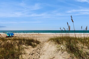 A beach with a tent and people in the distance.