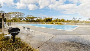 A swimming pool with lounge chairs and a barbecue grill. - Bright Condo with WiFi, W/D, Screened Porch & Community Pool/Tennis/Day Dock (Atlantic Beach)