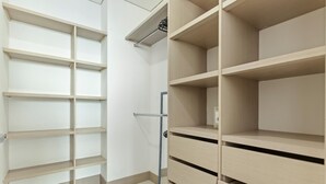 A room with a built-in wooden shelving unit and a separate wooden cabinet with drawers. - Ocean Bliss 2BR - Luxury Apartment | Bocagrande, Cartagena (Cartagena de Indias)