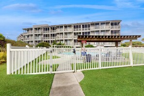 A multi-story hotel with a pool area, a no smoking sign, and a sign indicating pool hours. - 3rd-Floor Condo in Oceanfront Building w/Ocean Views, Shared Pool, Free WiFi (Atlantic Beach)