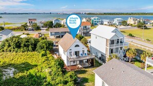 A coastal residential area with houses, a waterfront, and a prominent Atlantic Beach Realty sign.