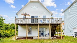 A two-story house with a balcony, a covered porch, and a small deck.