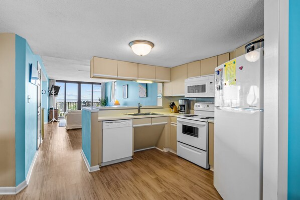 Cocina moderna con lavavajillas, estufa, microondas y refrigerador.