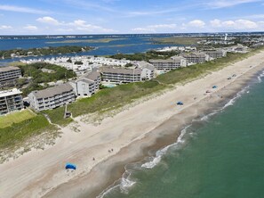Ein Küstenhotel mit mehreren Gebäuden, einem Sandstrand und Blick auf den Ozean.