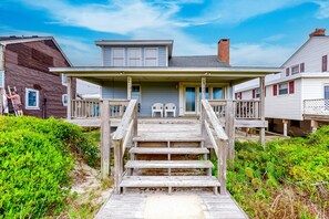 A wooden staircase leading to a porch with two chairs. - Beautiful Home in Oceanfront Location w/Vaulted Ceilings, Free WiFi, Deck, W/D (Atlantic Beach)