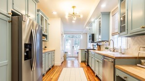 Una cocina equipada con refrigerador, estufa, lavamanos y armarios.