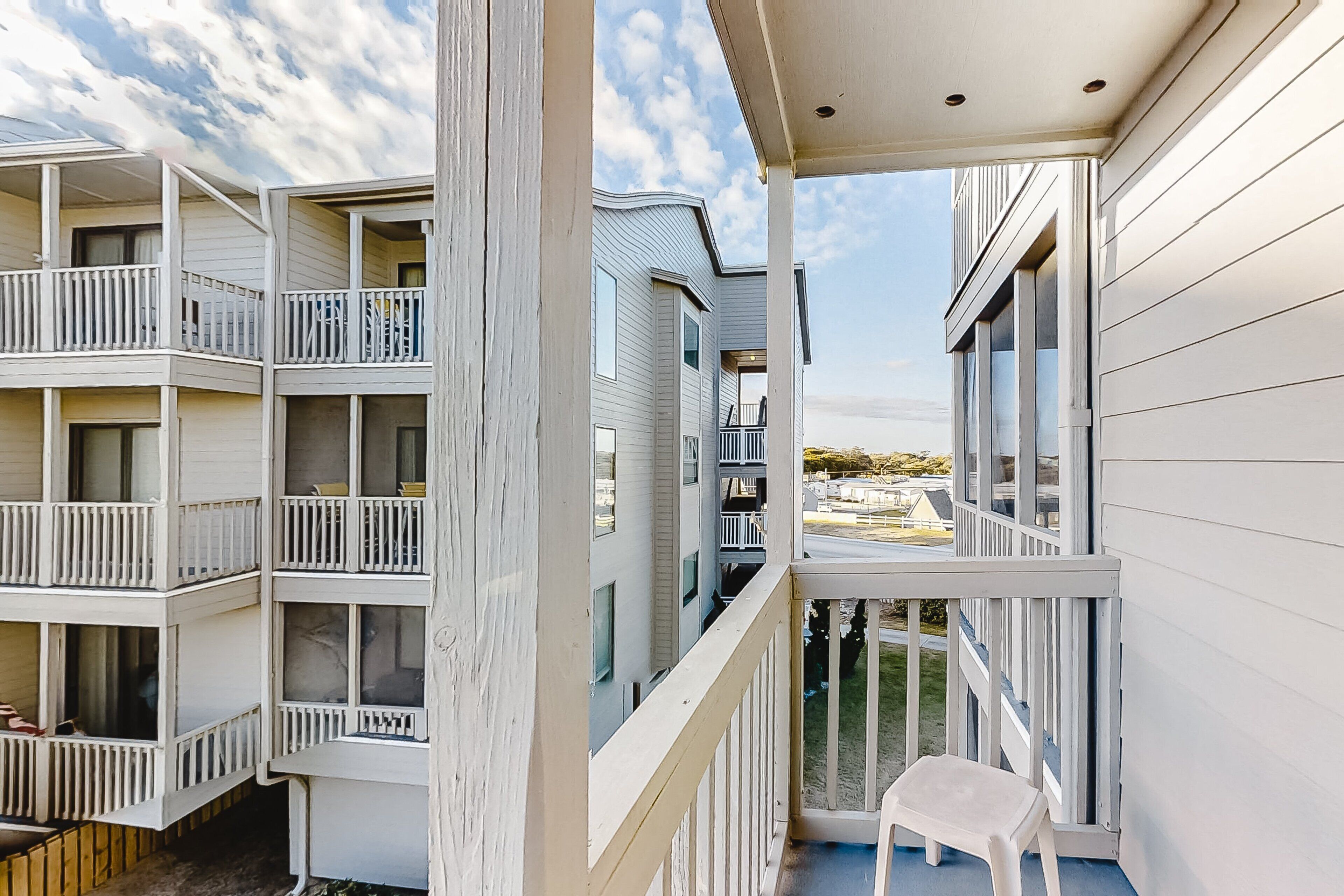 A multi-story building with balconies and large windows.