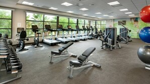 Un gimnasio con cintas de correr, elípticas y bancos de pesas.