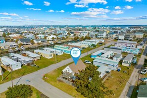 Vue aérienne d’un quartier résidentiel avec des maisons, une marina et un panneau indiquant les bureaux d’Atlantic Beach Realty.