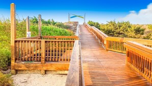 A wooden boardwalk leading to a beach area with a sign indicating a parking area. - First-Floor Condo with Balcony, WiFi & Shared Hot Tub, Pools, Tennis, Putt-Putt (Atlantic Beach)