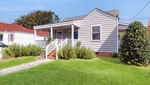 A single-story house with a front porch, a visible staircase, and a well-maintained lawn. - Dog-friendly cottage across from the water in a walkable neighborhood (Beaufort)