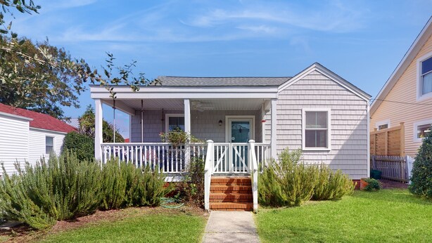 A single-story house with a front porch, a small brick step, and a clear pathway leading to the door. - Dog-friendly cottage across from the water in a walkable neighborhood (Beaufort)