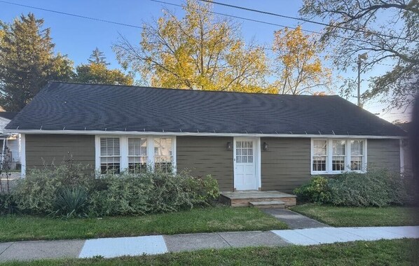 A single-story house with a dark roof, white trim, and a front porch. - Cozy Relaxing Getaway ~ Private Yard ~ Smart TV ~ Family Friendly (Seville)