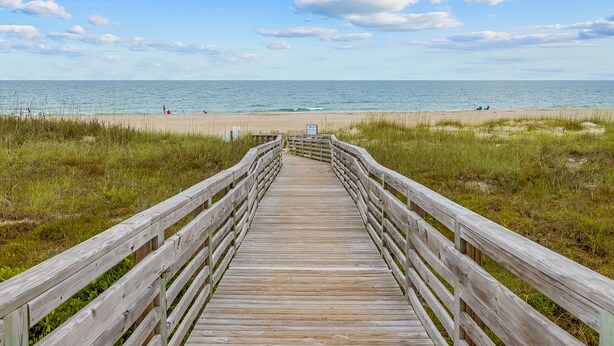 A wooden boardwalk leading to a beach with a clear sky. - Cheery coastal condo with balcony, AC, W/D, 2 pools, grills, & beach access (Atlantic Beach)