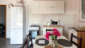 Una cocina moderna con refrigerador, microondas, estufa y armarios.
