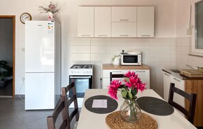 Une cuisine moderne équipée d’un réfrigérateur, d’un four à micro-ondes, d’une cuisinière et de placards.