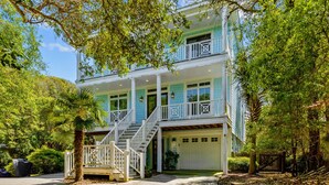 A two-story house with a front porch, a garage, and a covered driveway. - Dog-friendly home with ocean/sound views and private beach path (Pine Knoll Shores)