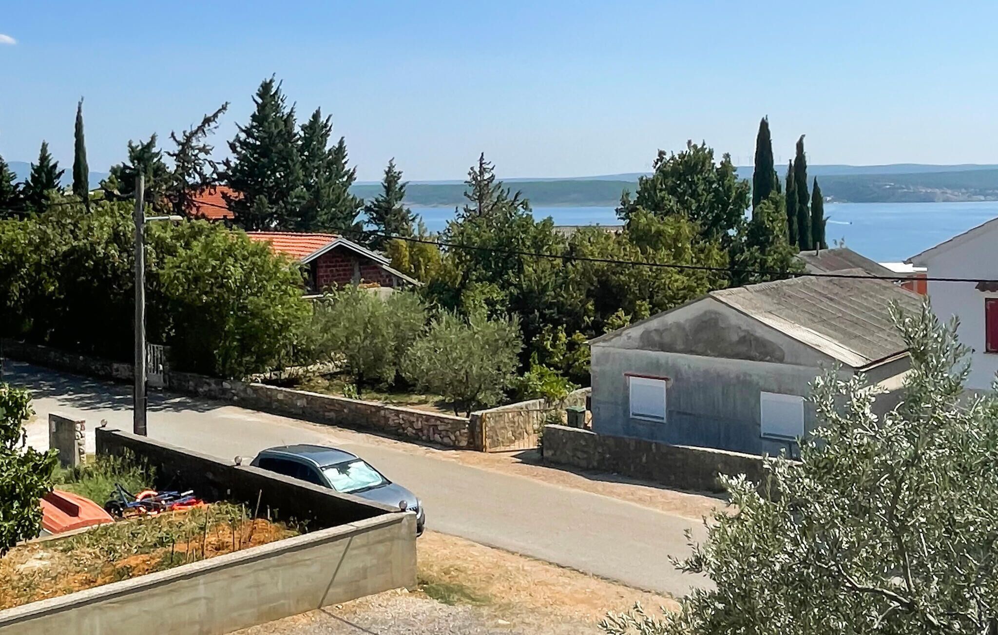 Un barrio residencial con una calle, casas y vista al mar.