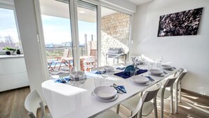A dining area with a table set for four, large windows, and a view of the outdoors.