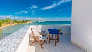 A balcony with a view of the sea, a table, and two chairs. - Lovely home in Privlaka (Privlaka)