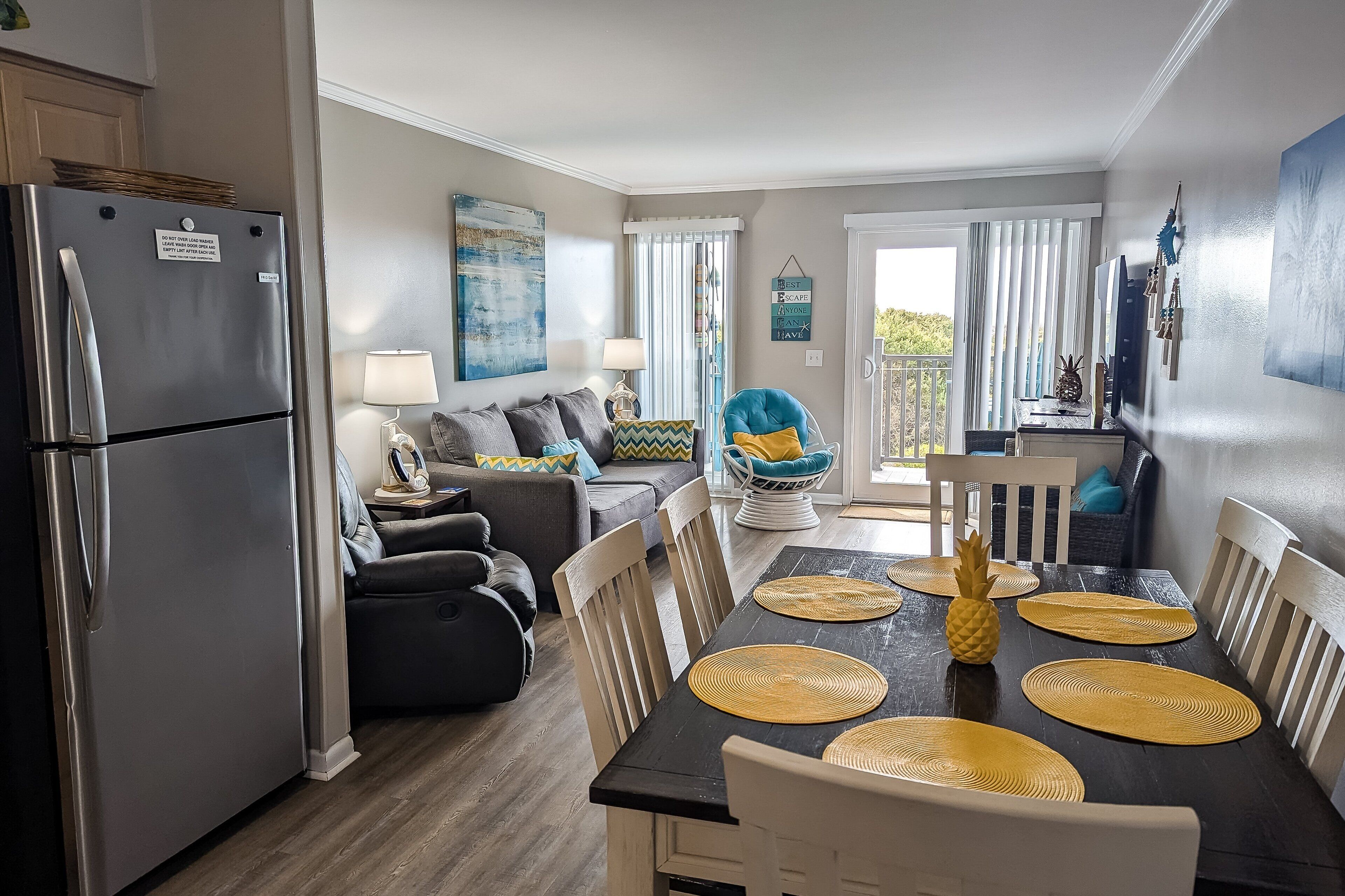 A compact living space with a kitchenette, a dining area with a table and chairs, a sofa, and a chair.