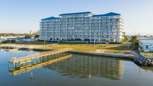 A multi-story hotel with balconies, a dock, and a marina.