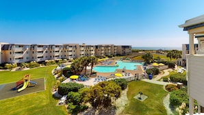 A resort with multiple swimming pools, a children's play area, and a well-maintained lawn. - 3rd-Floor Condo Overlooking Courtyard w/Beach Views, WiFi, Shared Pools/Hot Tub (Atlantic Beach)