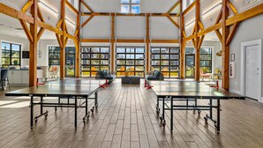 A spacious hall with wooden beams, large windows, and tables. - The Gough Coast; 3BR with seasonal pool access & community dock (Beaufort)
