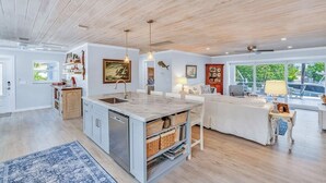 A modern kitchen with a central island, wooden ceiling, and large windows. - 3-bedroom waterfront house in fabulous Cudjoe Key (Cudjoe Key)