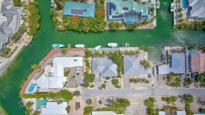 An aerial view of a coastal residential area with houses, a marina, and a swimming pool. - 3-bedroom waterfront house in fabulous Cudjoe Key (Cudjoe Key)