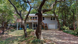 A two-story house with a covered porch and a garage. - Perfect 3BR Getaway with Central A/C, Full Kitchen and Relaxing Balcony (Emerald Isle)