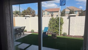 A patio with a table and chairs, a small tree, and a white wall. - Bright 4-bedroom house with AC in Lathrop (Lathrop)