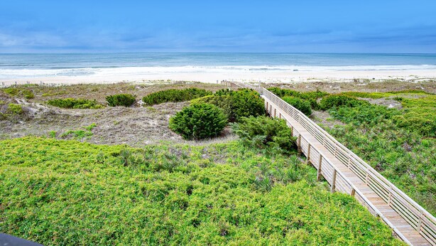 A wooden boardwalk leading to a beach with a clear view of the ocean. - First-Floor Condo with Balcony, WiFi & Shared Pools, Hot Tub, Tennis, Putt-Putt (Atlantic Beach)