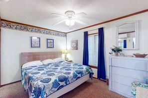 A bedroom with a bed, a dresser, a ceiling fan, and a mirror. - First-Floor Condo with Balcony, WiFi & Shared Pools, Hot Tub, Tennis, Putt-Putt (Atlantic Beach)