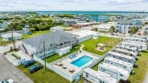 A residential area with a swimming pool surrounded by mobile homes and houses.