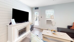 A living room with a fireplace, a flat-screen TV, a sofa, and a coffee table.