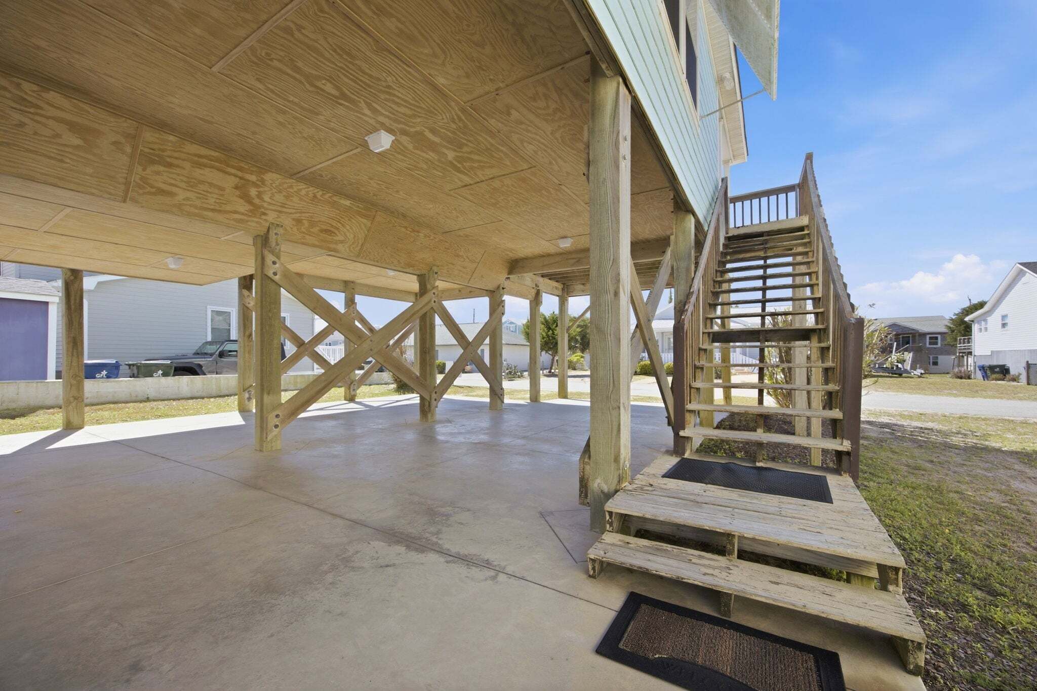 A wooden deck with a staircase leading to a covered area.