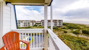 Ein Balkon mit Blick auf einen Strand und Wohnhäuser.