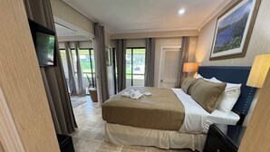 A hotel room with a large bed, a TV, a desk, and a view of the outdoors. - Pristine 1-bedroom condo w/1.5 Bath in World Renowned Innisbrook Golf Community (Palm Harbor)
