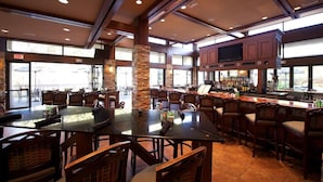 A spacious bar area with high ceilings, stone pillars, and a variety of seating options including tables and chairs. - Pristine 1-bedroom condo w/1.5 Bath in World Renowned Innisbrook Golf Community (Palm Harbor)