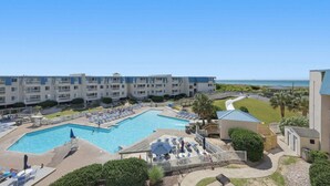 Un hôtel doté d’une piscine, de plusieurs balcons et offrant une vue sur l’océan.